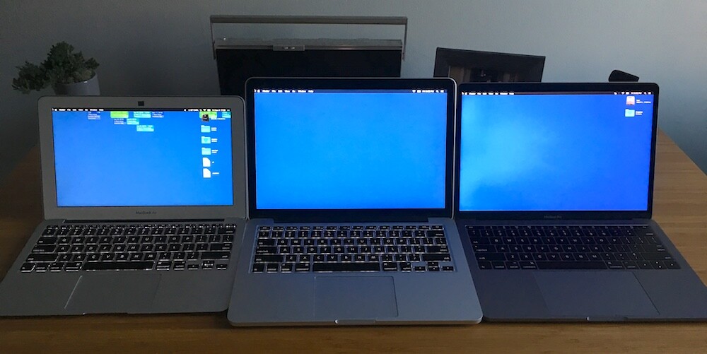 three macbook computers next to each other