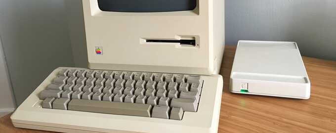macintosh computer on desk next to apple modem